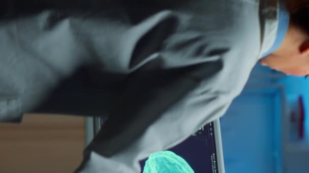 Pionowe wideo: Neurolog lekarz patrząc na monitor badania mózgu - Materiał filmowy, wideo