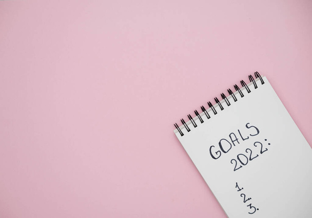 Notebook with text GOALS 2022 on pink background. Motivation, inspiration. Planning, plans and tasks. New business ideas. Setting goal, target. - Fotoğraf, Görsel