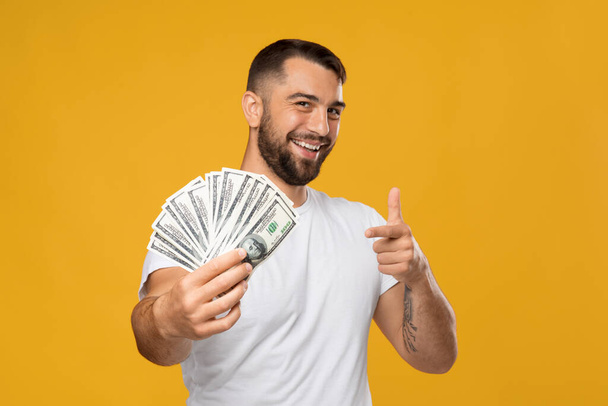 alegre feliz adulto europeo hombre se regocija de ganar, mantener muchos dinero, mostrando el dedo a la cámara - Foto, Imagen