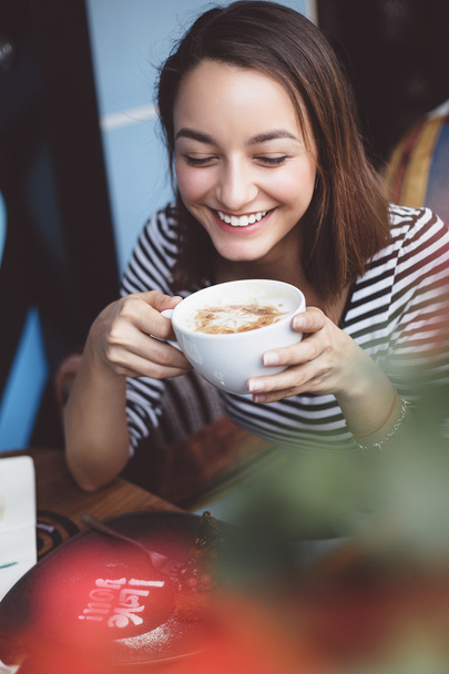 Mujer joven tomando café en la cafetería urbana
 - Foto, imagen