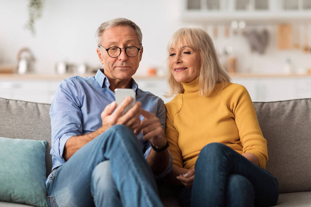 Senior marito e moglie utilizzando smartphone a casa - Foto, immagini