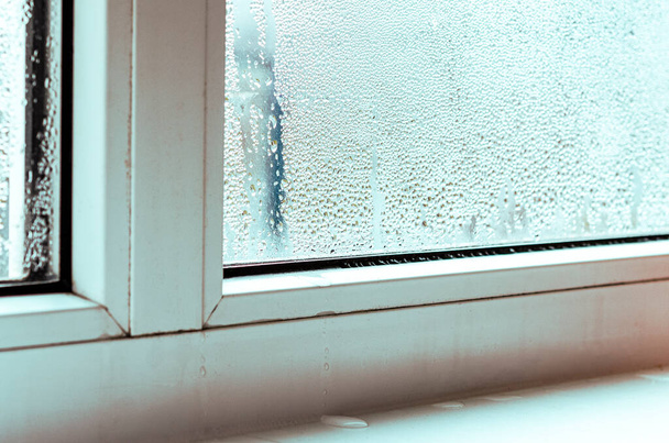 Druppels condensaat en zwarte schimmel op een wit kunststof venster. Close-up - Foto, afbeelding