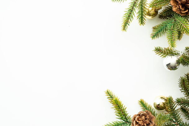 White table with Christmas decoration including pine branches and pine cones with golden balls. Merry Christmas and happy new year concept. Top view with copy space, flat lay. - Foto, Imagem