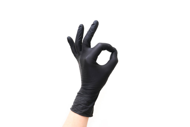 hand in black glove shows ok gesture on white isolated background - Zdjęcie, obraz