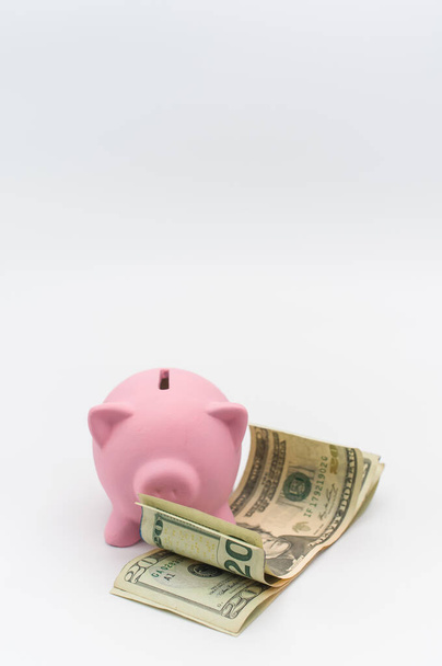 pink piggy bank and dollar banknotes on a white tabletop with copy space - Foto, Bild