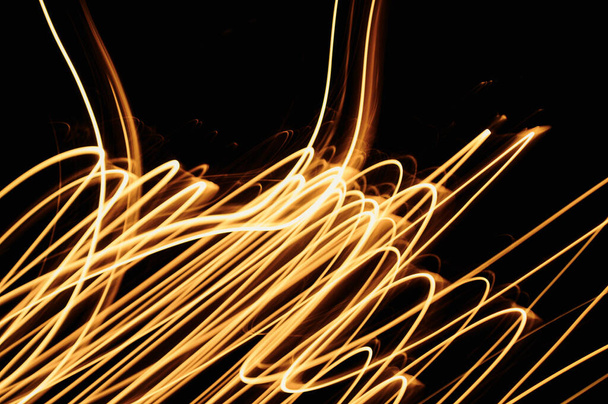 A futuristic yellow tangled fiber abstract lights on a dark background - Foto, Imagen