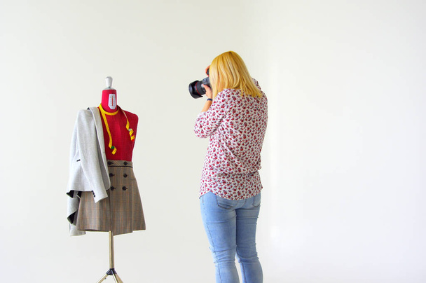Blondynka fotograf robi zdjęcia manekinowi w spódnicy i marynarce garnituru - Zdjęcie, obraz