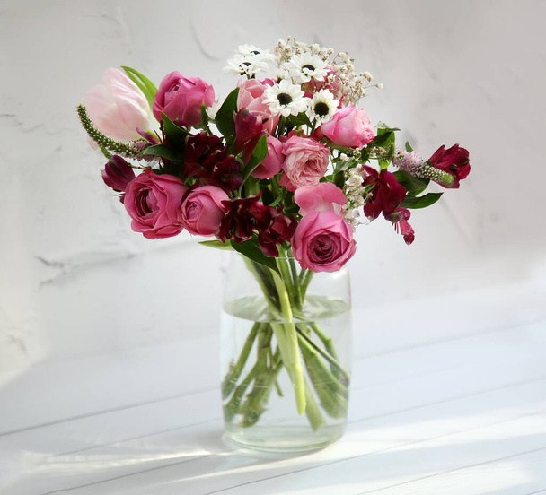 Rosa, weinrote und weiße Blumen - Tulpen, Alstroemeria, Rosen, Nelken, Chrysanthemen in einem Strauß auf weißem Hintergrund. Grußkarte, Blumen, Kopierraum  - Foto, Bild