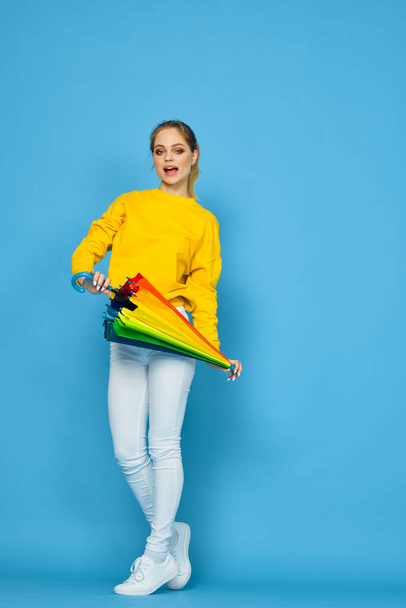 woman with multicolored umbrella in yellow sweater posing rainbow colors - Foto, imagen