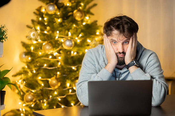 zklamaný muž sedí před počítačem na Silvestra v kanceláři - Fotografie, Obrázek