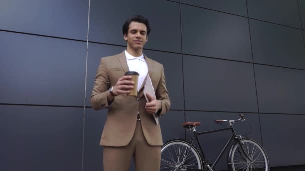 sikeres férfi öltönyben iszik kávét, hogy menjen és ellenőrizze idő kívül  - Felvétel, videó