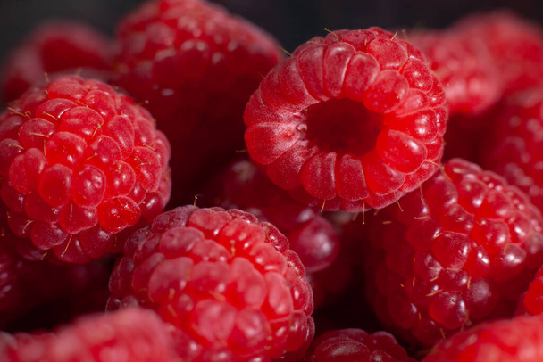 Stack of delicious cleaned raspberries. Sweet raspberries are grown in the garden - Фото, изображение