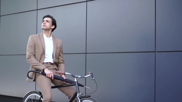 fiatal férfi öltönyben nyitó esernyő és kerékpár  - Felvétel, videó
