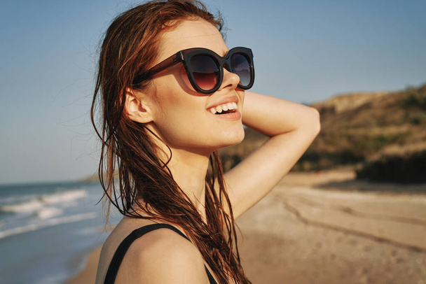 cheerful woman in sunglasses in a swimsuit on the beach sun island - 写真・画像