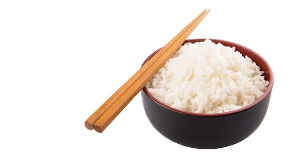 米と白い背景の上の箸のペアのボウル - 写真・画像