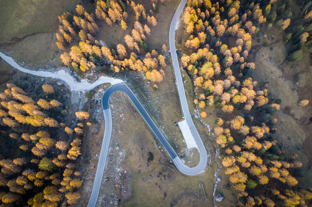 Spectacular aerial view of awinding and curvy road in the italian Dolomites during beautiful golden autumn - Foto, Imagem