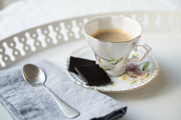 Elegante taza de café espresso negro con chocolate negro en una hermosa bandeja blanca en la cafetería - Foto, imagen
