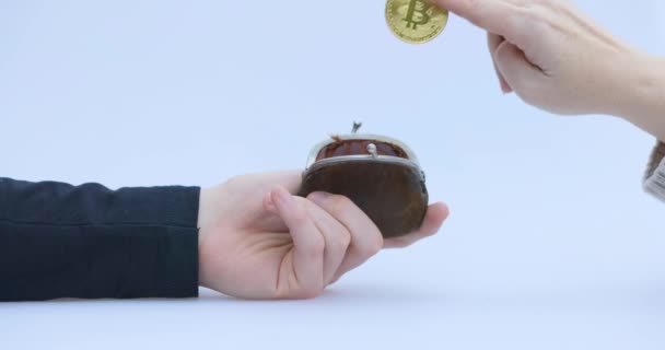 Männliche Hand steckt eine Kryptomünze, Bitcoin oder BTC, in eine kleine braune Brieftasche, die zeigt, wie man mit Krypto- oder Kryptowährung verdient oder bezahlt und spart, hält oder hortet - Filmmaterial, Video