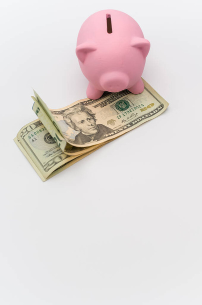 pink piggy bank and dollar banknotes on a white tabletop with copy space - Foto, immagini