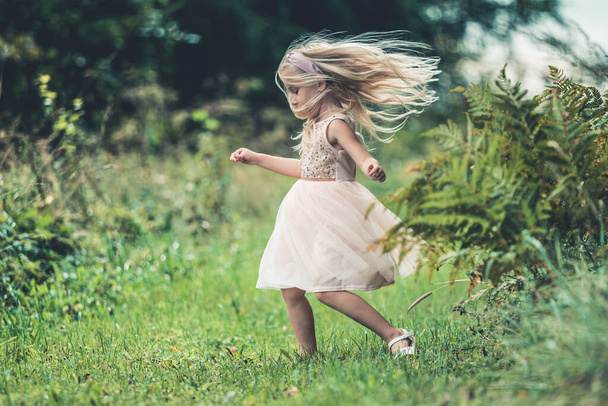 Meisje draait rond, danst buiten in het bos - Foto, afbeelding