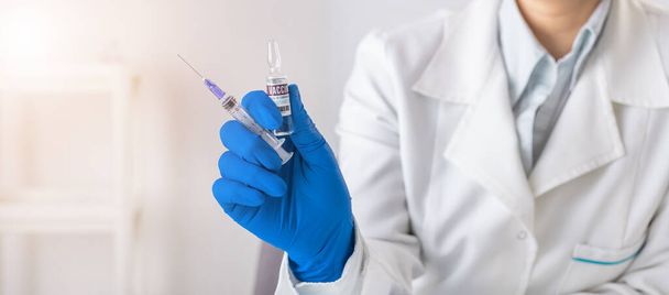 Doctor holding vaccine and syringe - Foto, Imagen