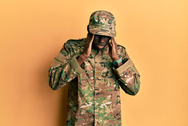Joven afroamericano vestido con uniforme del ejército con la mano en la cabeza, dolor de cabeza porque el estrés. padecer migraña.  - Foto, Imagen
