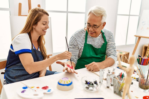 Два художника средних лет улыбаются счастливыми руками в художественной студии. - Фото, изображение