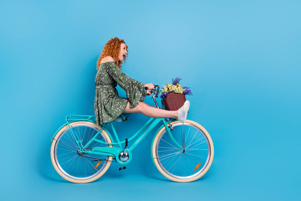 Full body profile photo of cool lady ride bike wear dress sneakers isolated on blue color background - Foto, afbeelding