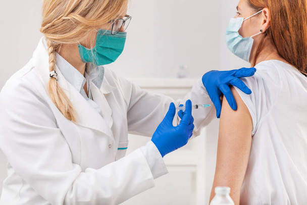 Doctor vaccinating female patient - Foto, Bild