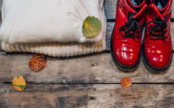 Jumper de lã quente na moda e sapatos vermelhos no fundo de madeira rústica. Deitado plano, vista superior. Senhora moda roupas conjunto.  - Foto, Imagem
