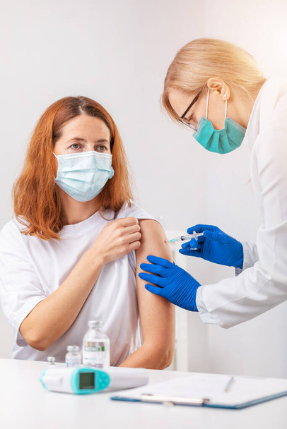 Woman getting vaccinated at clinic - Foto, immagini