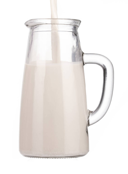 Milchgießen in Krug isoliert auf weißem Hintergrund - Foto, Bild