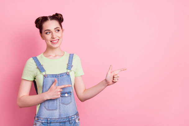 Photo of girl direct finger empty space look side wear sunglass jeans overall green t-shirt isolated on pink background - Foto, immagini