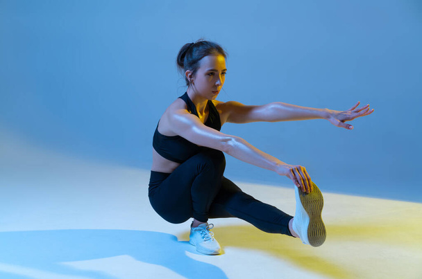 Athletic woman doing squats on one leg. Workout lesson. - Foto, Imagem
