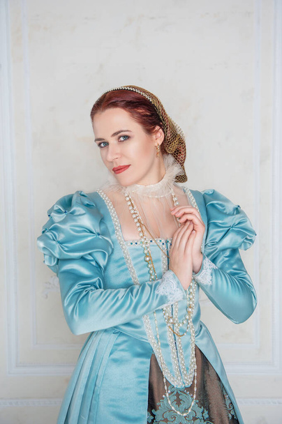 Kaunis nuori nainen keskiaikaiseen tyyliin sininen mekko huoneessa - Valokuva, kuva