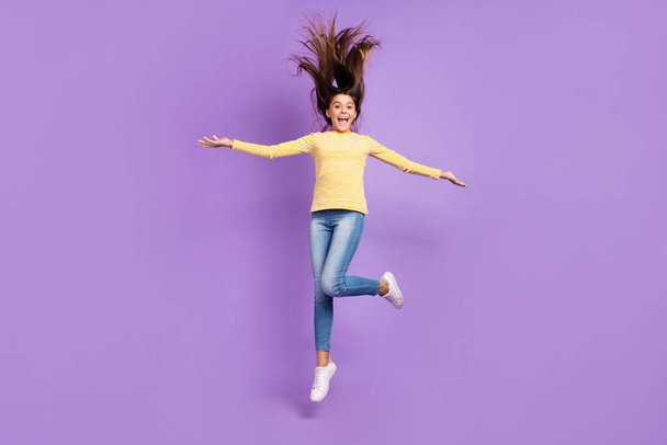 Full body photo of young lovely girl jump up wear casual clothes dream active isolated over violet color background - 写真・画像