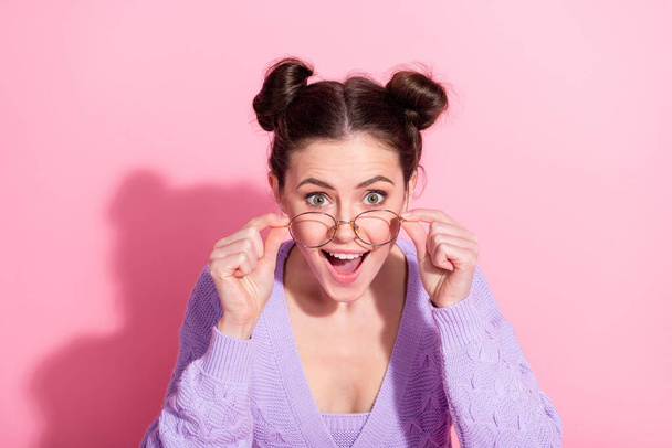 Photo portrait of amazed girl taking off glasses wearing cardigan staring with opened mouth isolated on pastel pink color background - Foto, Bild