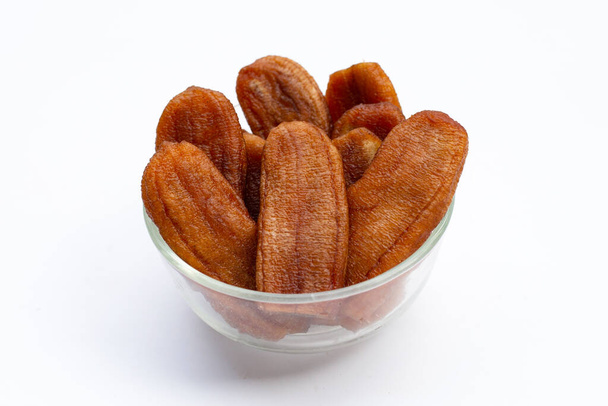 Sun dried bananas in glass bowl on white background. - Photo, Image