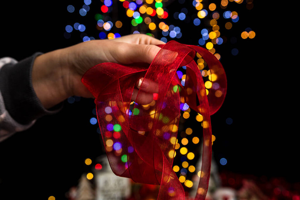 Holding Christmas decoration against bokeh lights background - Φωτογραφία, εικόνα