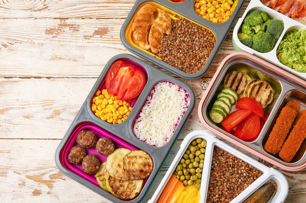 Veel containers met gezond voedsel op lichte houten achtergrond, close-up - Foto, afbeelding