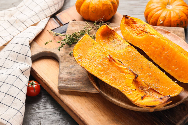 Plate with baked pumpkin pieces on wooden background - Foto, Imagem
