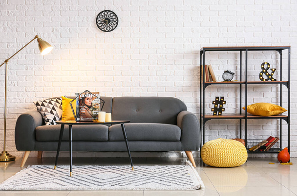 Interno del soggiorno con comodo divano, lampada da terra luminosa e mensola - Foto, immagini