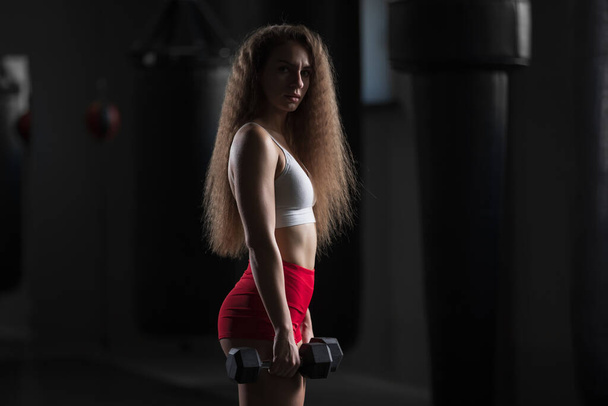 Fit woman portrait, standing with dumbbells in the gym - Fotó, kép