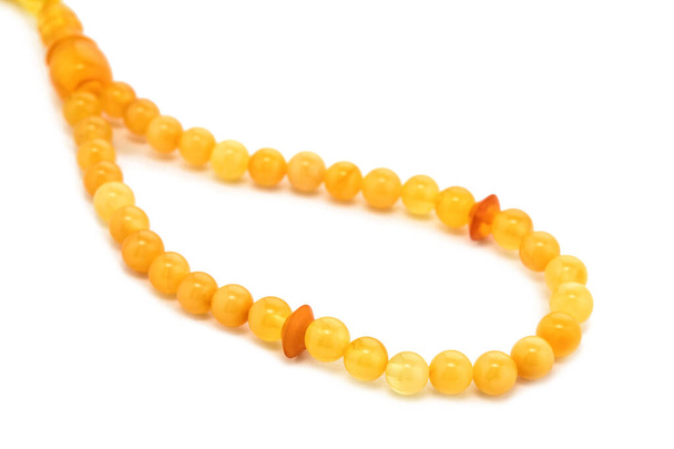 Baltic necklace made of Natural polished transparent honey luxury amber beads with inclusions on white. close up selective soft focus. Space for text - Photo, Image