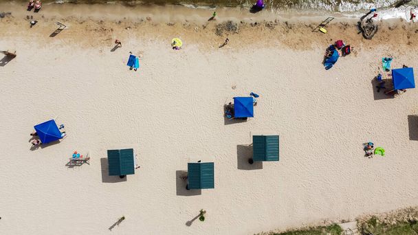 Ombrelloni e attività in spiaggia sulle coste sabbiose del City Beach Park di Granbury, Texas. Diverse persone godono di prendere il sole, edificio castello di sabbia e attività estive per famiglie - Foto, immagini