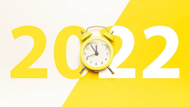 Nowy rok 2022. Retro stylu żółty zegar w Wesołych Świąt północy. Odliczanie do szczęśliwych Świąt na żółtym tle. Wesołych Świąt i Szczęśliwego Nowego Roku - Zdjęcie, obraz