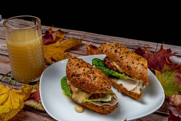 Burger z kurczaka w bagietce z nasionami jalapenos z oliwek warzywnych ze świeżym sokiem gruszkowym - Zdjęcie, obraz