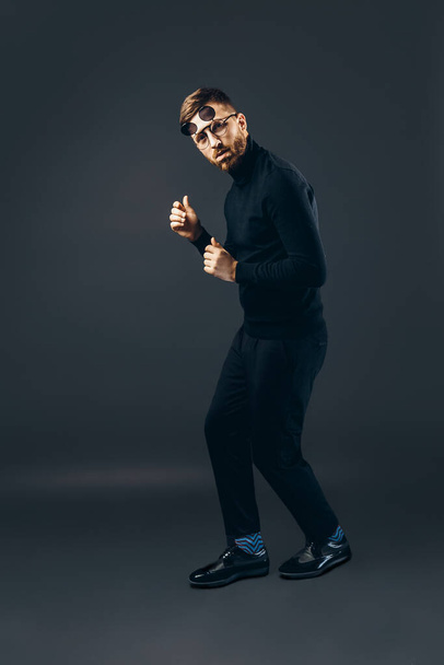 Full length of hipster man in fun in black performing show dance who isolated on black background. - Photo, image