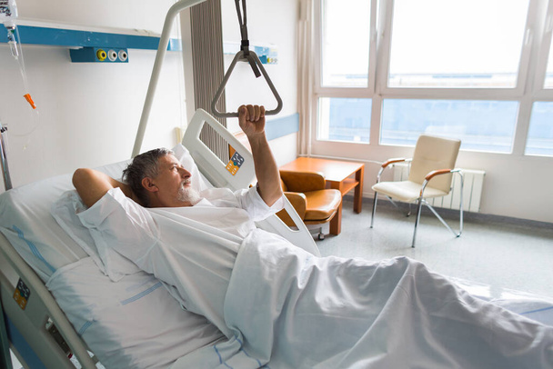 Patient at a hospital, looking from a window in his room, doing much better after the surgery - Foto, Imagen