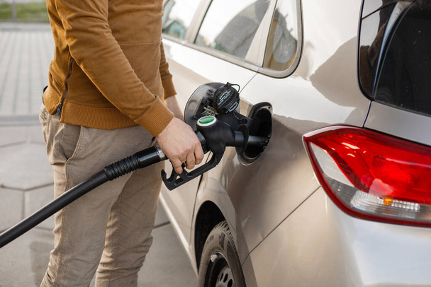 Car refueling on the petrol station. Man refilling the car with fuel. Close up view. Gasoline, diesel is getting more expensive. - Photo, image
